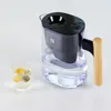 A water filter pitcher and a glass of water with lemon slices on a white background. Podgląd zdjęcia produktu