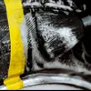 A close-up shot of a detailing brush with soap suds, next to a yellow stripe. Anteprima dell’immagine prodotto
