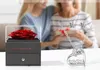 A gift set for mom, featuring a preserved rose and jewelry, with two women in the background. Náhľad obrázku produktu