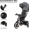 A close-up view of a gray and black children's tricycle, with inset images highlighting safety features. Produktbild-Vorschau