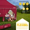 A family is sitting under a red pop-up gazebo in a grassy outdoor setting. Produktbild-Vorschau