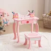 A child's pink vanity desk and stool set with art supplies on a fluffy rug. Podgląd zdjęcia produktu