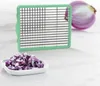 A kitchen gadget for dicing onions is shown next to a pile of diced onions and a halved onion. Produktbild-Vorschau
