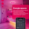 A bedroom with bunk beds, illuminated by pink and yellow smart lights, with a phone displaying a smart home app. Produktbild-Vorschau
