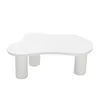 A white, cloud-shaped coffee table with three cylindrical legs, isolated on a white background. Produktbild-Vorschau