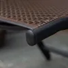 Close-up of the corner of a brown polyrattan chair seat with a black frame and a black plastic foot. Voir les images du produit