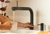 A person is filling a glass with hot water from a modern black faucet in a kitchen sink. Produktbild-Vorschau