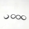 Four circular objects with black rims and white centers are arranged in a line on a light gray background. Voir les images du produit