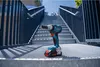 A Bosch cordless impact wrench is placed on a metal staircase landing, with a modern architectural structure in the background. Voir les images du produit