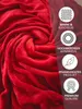 A close-up of a red plush blanket with marketing icons and text on the right side. Produktbild-Vorschau
