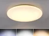 A round, white ceiling light fixture with small star-like accents, mounted on a light gray ceiling. Produktbild-Vorschau
