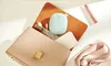 A collection of items, including a handbag, a power bank, a charging cable, a lipstick, and a Philips Avent device, are arranged on a light-colored surface. Produktbild-Vorschau