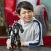 A young boy is smiling and holding a Venom action figure. Voir les images du produit
