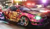 A stylized, pink sports car with anime-style graphics is driving at night on a city street, with blurred lights and police car lights in the background. Produktbild-Vorschau