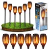 A set of solar garden lamps with a flame effect, displayed on a patch of grass, next to their packaging. Náhled obrázku produktu