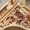 A close-up view of a wooden mechanical toy with intricate gears and decorative elements. Podgląd zdjęcia produktu