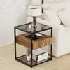 A bedside table with a lamp and books next to a bed. Produktbild-Vorschau