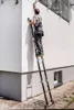 A person is using a multi-purpose ladder to clean a gutter on the side of a building. Náhľad obrázku produktu