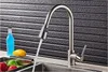 A kitchen faucet with water running, next to a bottle of blue liquid, a lemon, and some fruits in a sink. Náhľad obrázku produktu