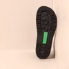 The sole of a black boot is shown leaning against a white wall. Voir les images du produit