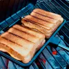 Two grilled sandwiches in a sandwich maker on a grill. Produktbild-Vorschau