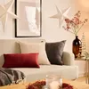 A cozy living room scene with a sofa adorned with decorative pillows and Christmas-themed decor. Voir les images du produit