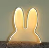 A bunny-shaped night light is mounted on a wall above a textured surface. Produktbild-Vorschau