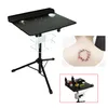 A black tattoo workstation with a tripod base, shown on a white background. A small inset image shows a tattoo on a person's neck. Náhled obrázku produktu