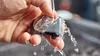A hand holding a hair clipper head under running water. Anteprima dell’immagine prodotto