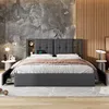 A bedroom scene featuring a bed with storage drawers and a headboard with built-in shelves and charging capabilities. Náhled obrázku produktu