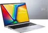 A silver Asus Vivobook laptop is shown from a diagonal front-facing angle, with its screen displaying a colorful abstract wallpaper. A second, identical laptop is visible in the background, showing its lid. Produktbild-Vorschau
