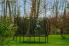 A boy is jumping on a trampoline in a backyard. Náhled obrázku produktu