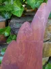 A close-up of a rusty metal angel wing decoration against a stone wall and ivy. Produktbild-Vorschau
