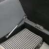 Close-up view of the interior of a storage bench, showing a gas strut mechanism and a folded blanket. Produktbild-Vorschau