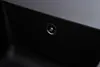 A close-up view of a black sink with a silver drain. Produktbild-Vorschau