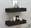 Two black floating shelves are mounted on a light gray wall, decorated with various home decor items. Produktbild-Vorschau