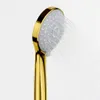 A close-up shot of a gold shower head with water spraying from it. Produktbild-Vorschau