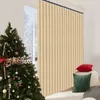 A Christmas tree and decorative pillows are placed in front of a beige vertical blind. Náhled obrázku produktu