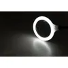 A close-up of a magnifying glass with an LED light ring, casting a bright light on a dark surface. Produktbild-Vorschau