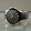 A close-up studio shot of a luxury watch on a reflective surface. Produktbild-Vorschau