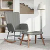 A gray velvet rocking chair and ottoman are placed on a rug in a room with shelves and a floor lamp. Náhľad obrázku produktu