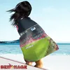 A person on a beach with a blanket draped over them, showing a football stadium. Anteprima dell’immagine prodotto