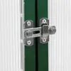 Close-up of a latch on a green door frame, with a translucent ribbed panel to the left. Produktbild-Vorschau