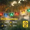 Butterfly-shaped string lights hanging outdoors in the rain, with text indicating they are waterproof. Produktbild-Vorschau