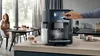 A person is using a Siemens coffee machine in a modern kitchen setting. Produktbild-Vorschau