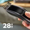 A hand is holding a hair clipper, showing the adjustable length settings. Náhled obrázku produktu