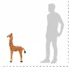 A plush giraffe toy is shown next to a silhouette of a person for scale. Náhľad obrázku produktu