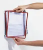 Hands are shown holding and adjusting a red-framed document holder attached to a wall-mounted system. Anteprima dell’immagine prodotto