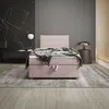 A bedroom scene featuring a pink upholstered bed. Voir les images du produit