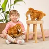 A young girl is sitting on the floor with a stuffed mammoth toy, and another stuffed mammoth is on a wooden stool. Voir les images du produit